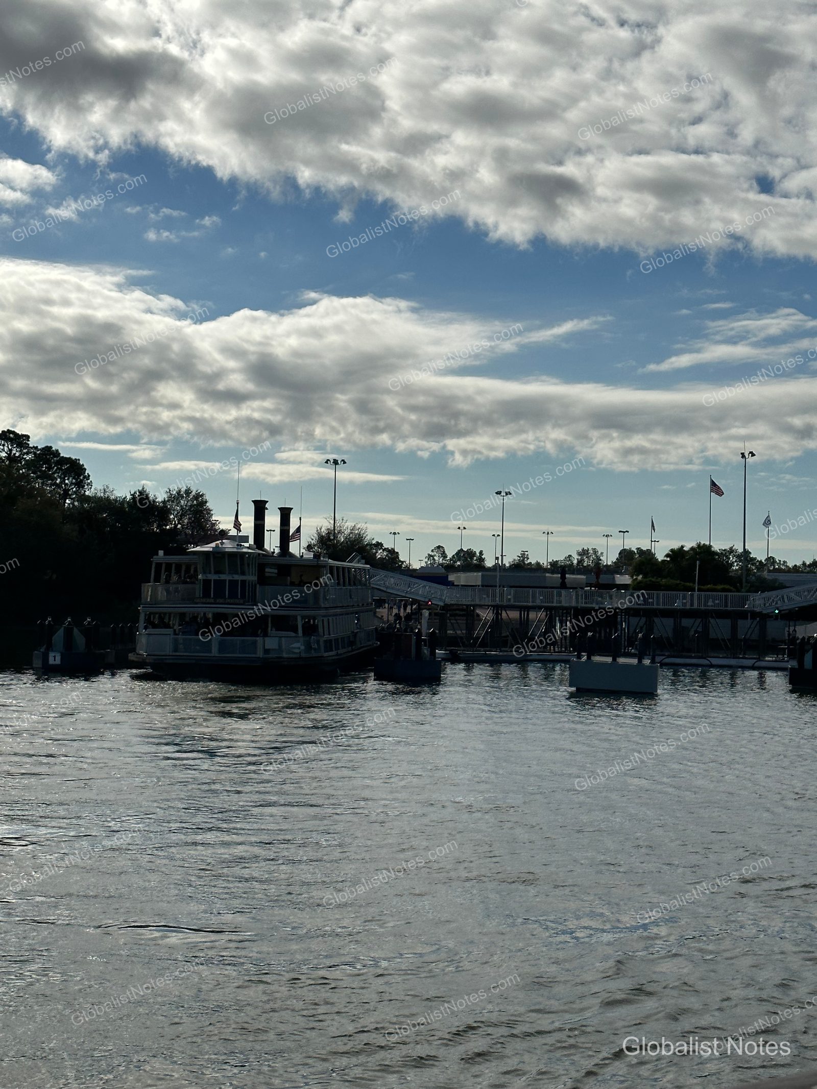 A steamboat-style excursion boat docked at the lake near Hyatt Regency Grand Cypress in Orlando, with a cloudy sky and pier facilities in the background.