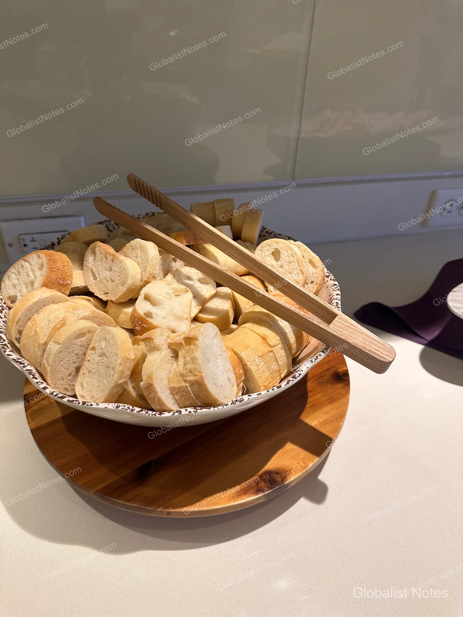 Sliced baguettes in a round bowl with wooden tongs at the breakfast buffet at Hyatt Regency Maui Resort and Spa.