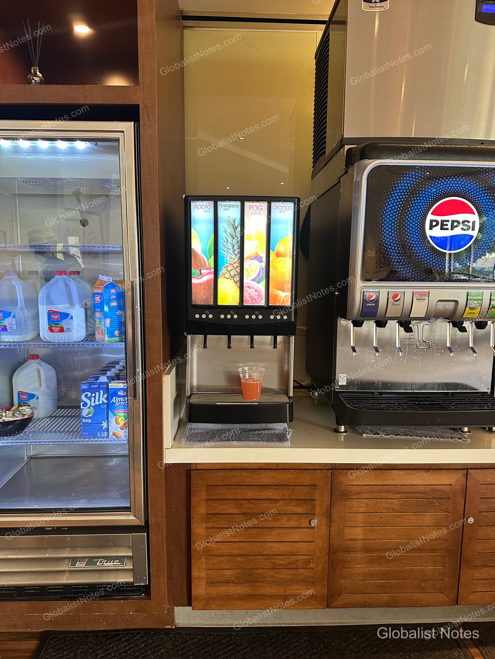 Beverage station at Hyatt Regency Maui Resort and Spa in Lahaina, Hawaii. The left side features a refrigerator with milk, soy milk, and almond milk; the center has dispensers for apple, pineapple, POG, and orange juice; and the right side has a Pepsi soda fountain.