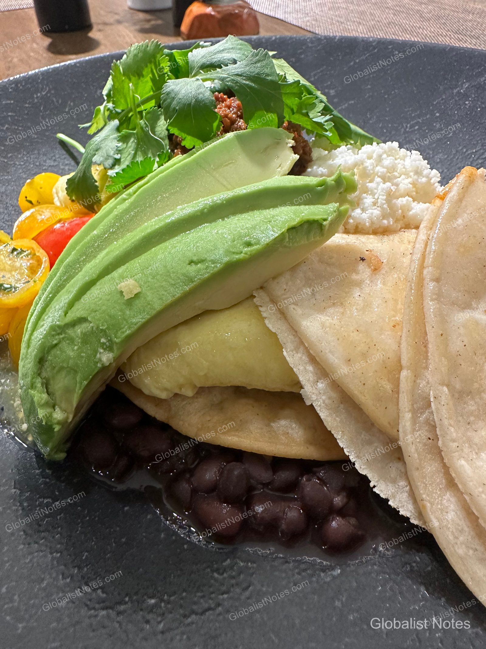 Hyatt Regency Newport Beach West 的早餐，黑色餐盤盛裝著酪梨切片、黑豆、起司、番茄與香菜，並附上薄餅。