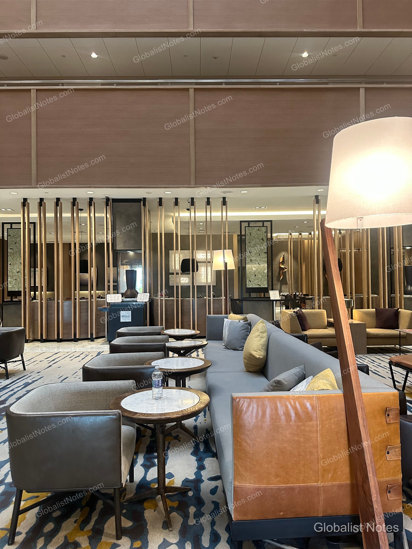 Hyatt Regency Newport Beach 大廳休息區，挑高天花板綴以木質格柵，配置現代風格的灰色沙發與皮革細節座椅。
