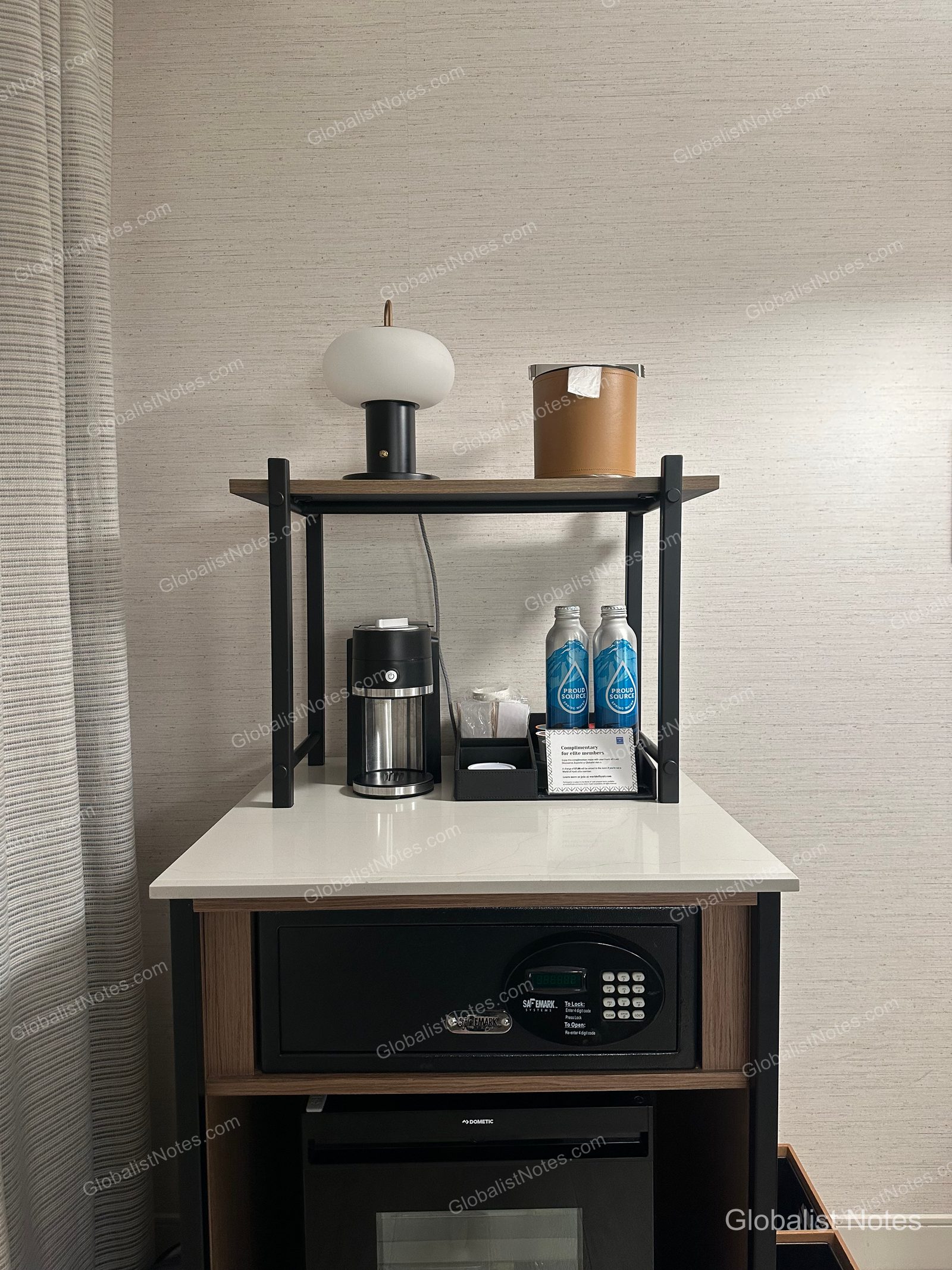 Hyatt Regency Irvine 一房套房內的迷你吧區域。白色檯面上擺放咖啡機、兩瓶瓶裝水、杯具、檯燈與冰桶，下方則內嵌保險箱與 Dometic 冰箱。