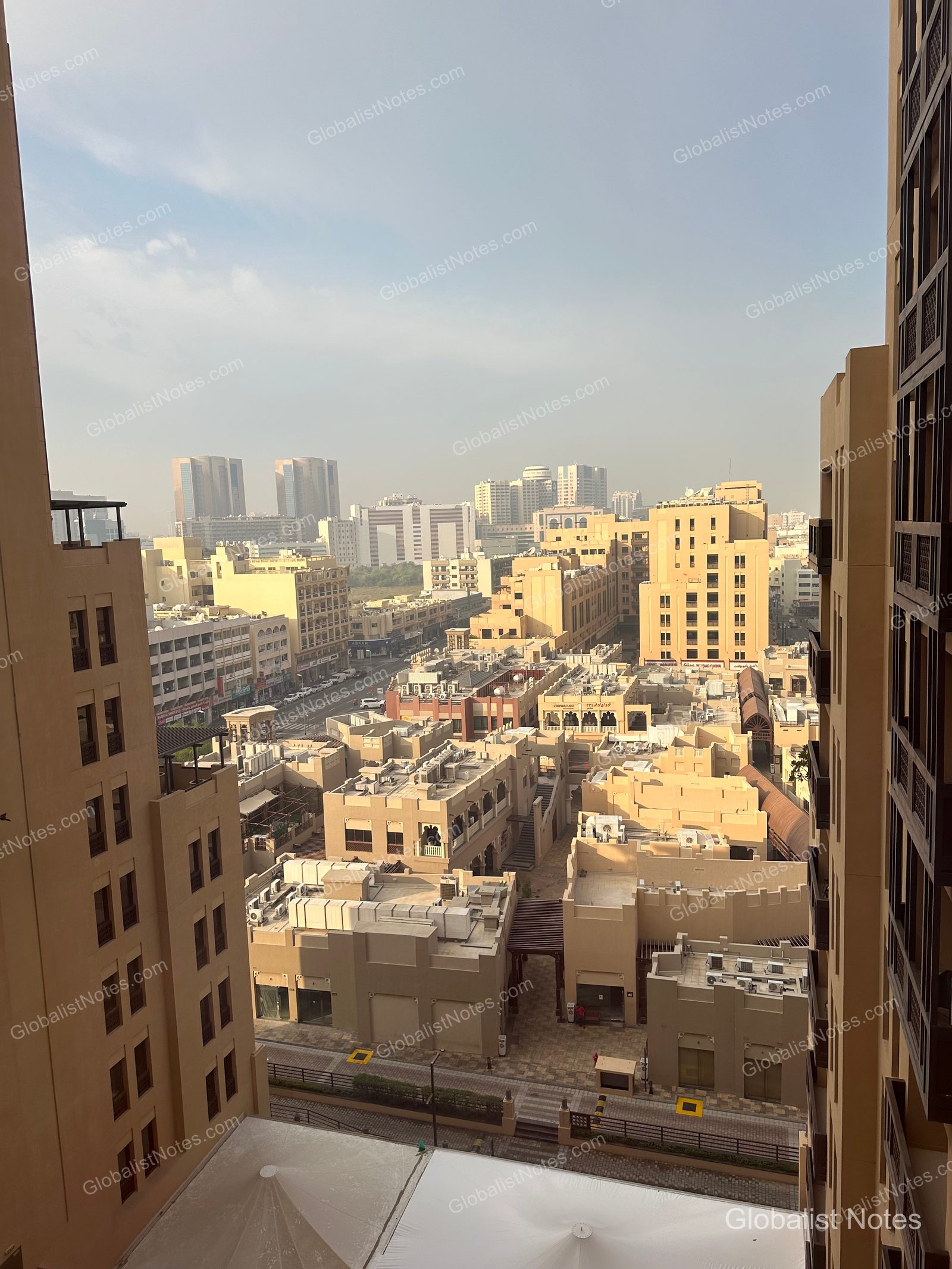 從 Hyatt Place Dubai Wasl District 客房俯瞰的市景。密集的土黃色低矮建築與遠處高樓形成對比，展現出杜拜的城市日常。