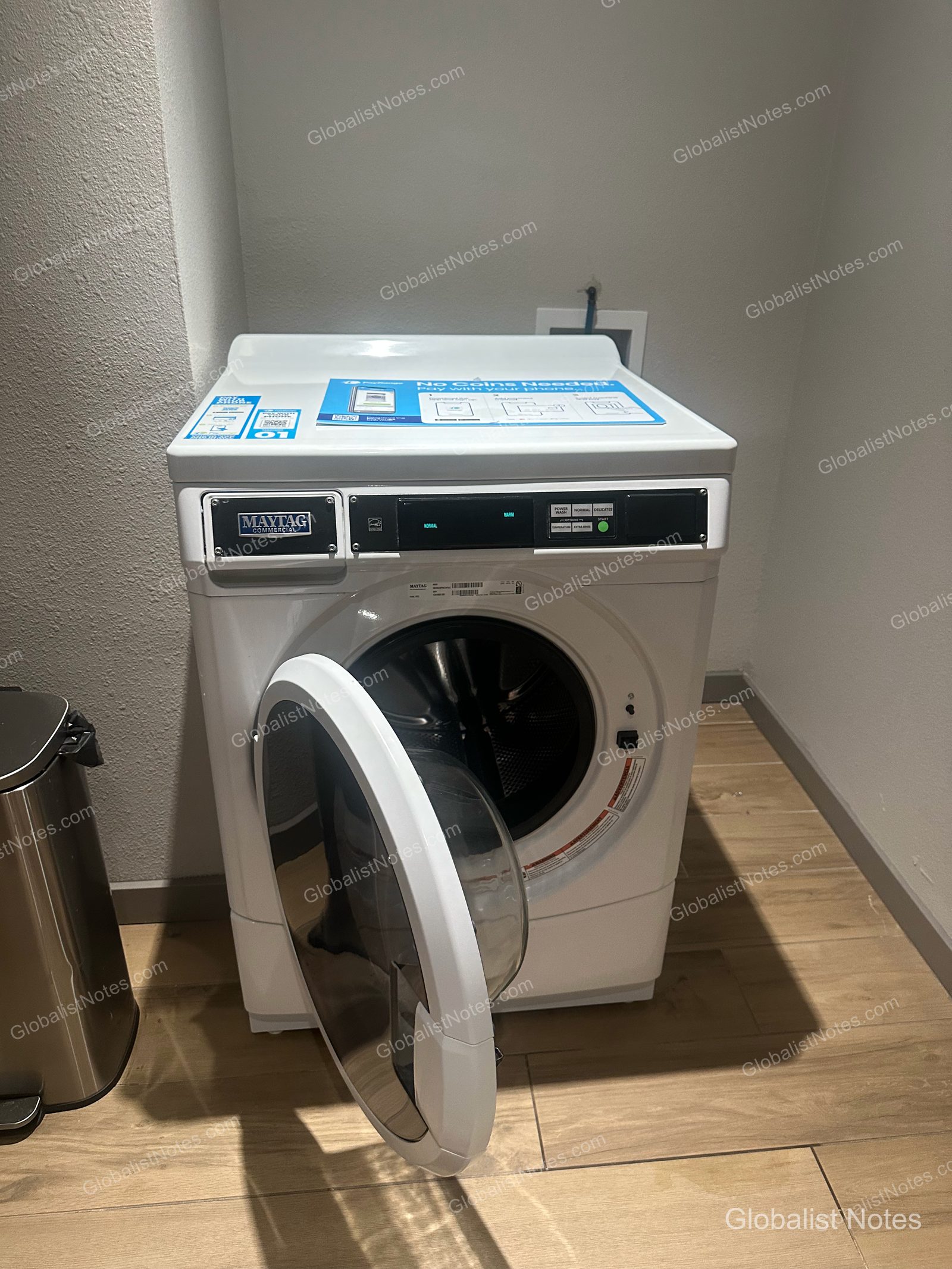 Hyatt Place Flagstaffの館内に設置されたMaytag製の業務用洗濯機。ドラム式洗濯機の扉が開いており、上部にはモバイル決済の案内が掲示されています。床は明るい木目調のタイル張りです。
