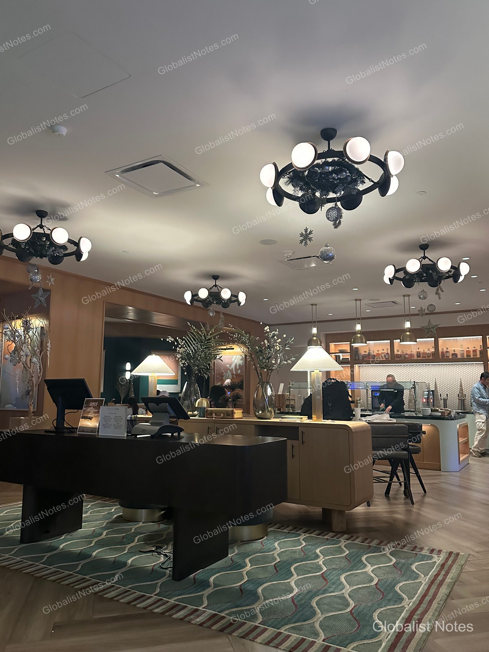 Hyatt Regency Irvine 貴賓廳內部，天花板懸掛圓形燈飾並裝飾冬季節慶元素，中央設有長桌，後方為餐飲服務櫃檯。