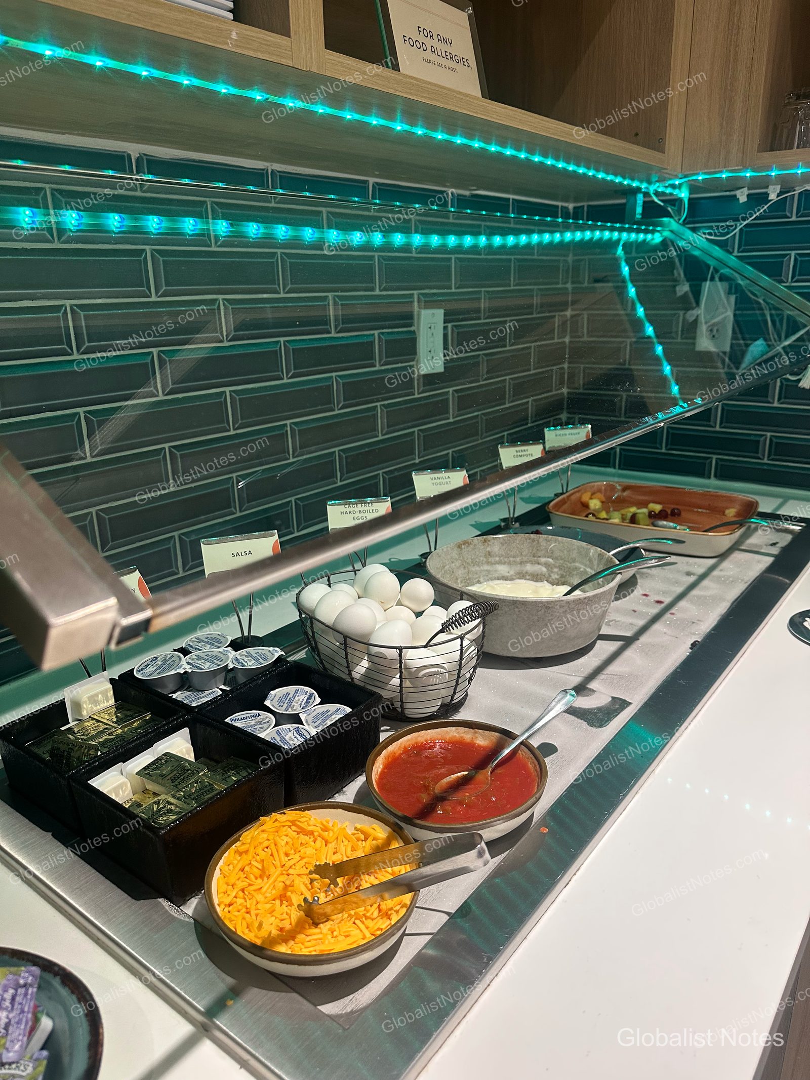 Hyatt Place Flagstaffの朝食ビュッフェ。ゆで卵、サルサ、チェダーチーズ、ヨーグルトなどが並び、上部には食物アレルギーに関する案内が掲示されている。