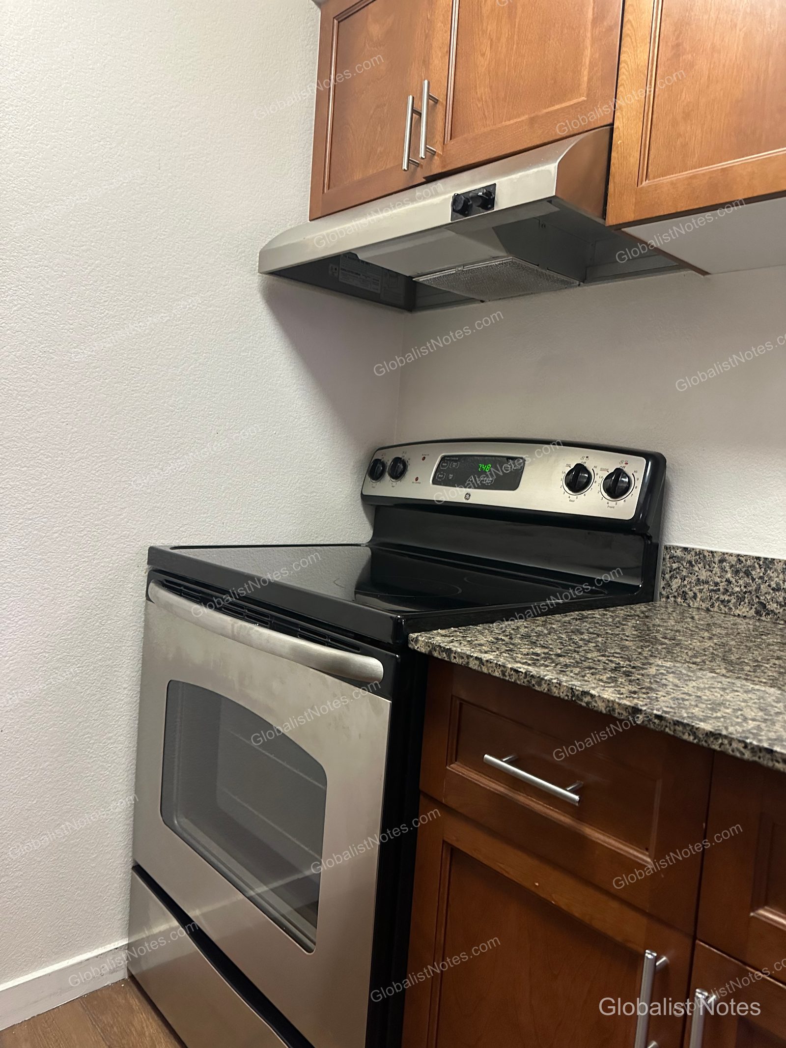 Hyatt House Scottsdale/Old Townの1ベッドルームスイートのキッチン。GE製の電気コンロとオーブン、換気フードが備わり、横には花崗岩のカウンタートップが広がっています。