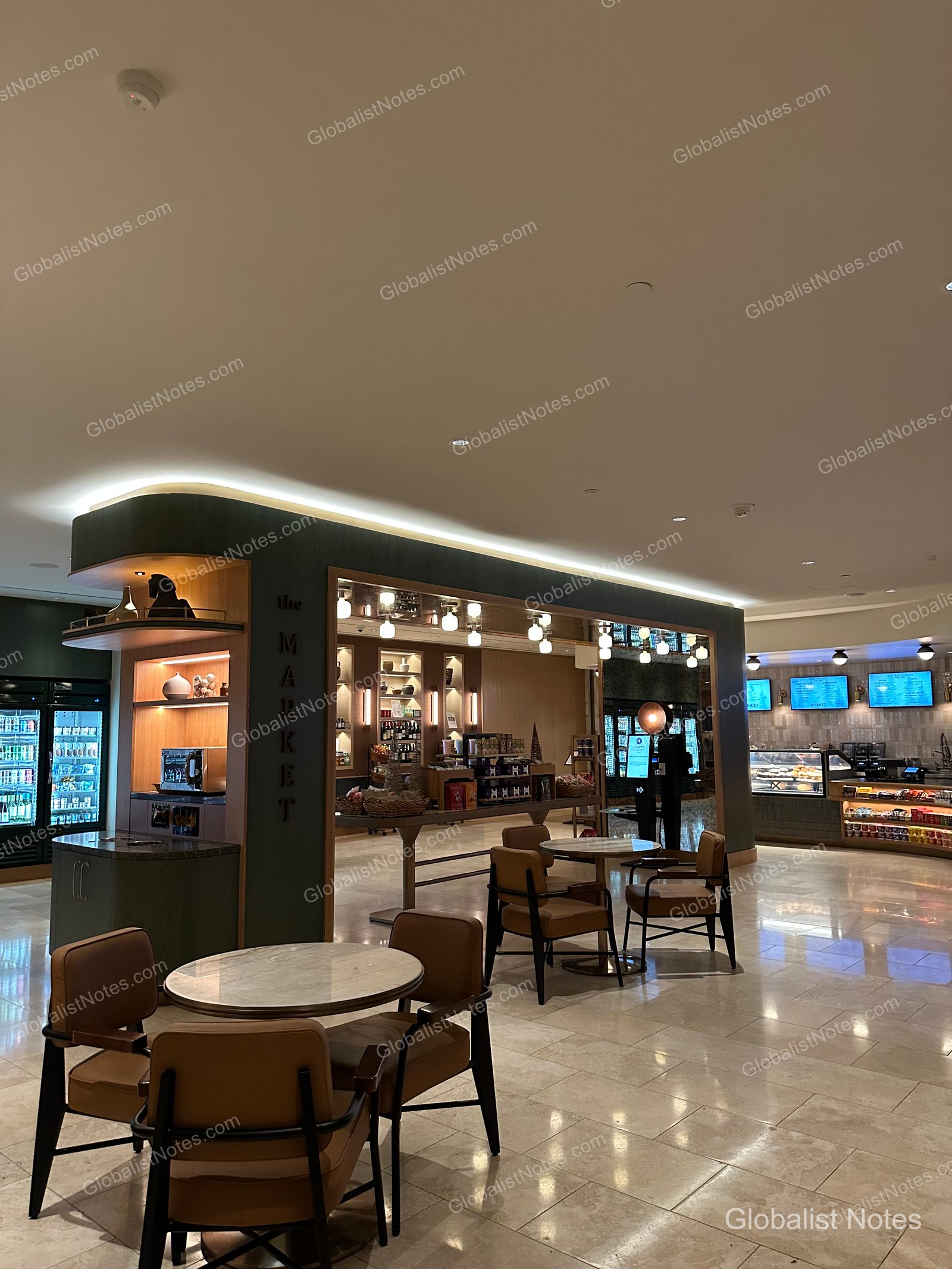 Hyatt Regency Irvine 大廳樓層的「The Market」商店全景。可見深綠色邊框的店面入口、內部陳列架，以及前方的圓桌與棕色皮椅。後方則為飲料冷藏櫃與零食陳列櫃檯。