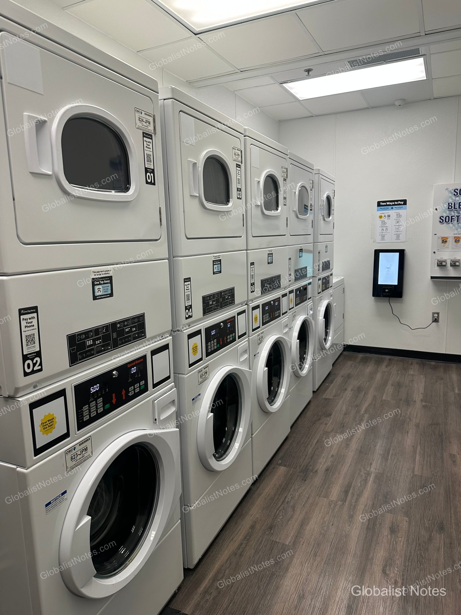 Inside the laundry room at Grand Hyatt San Antonio River Walk, featuring a row of white washers and dryers, with mobile payment instructions and a detergent vending machine mounted on the wall.