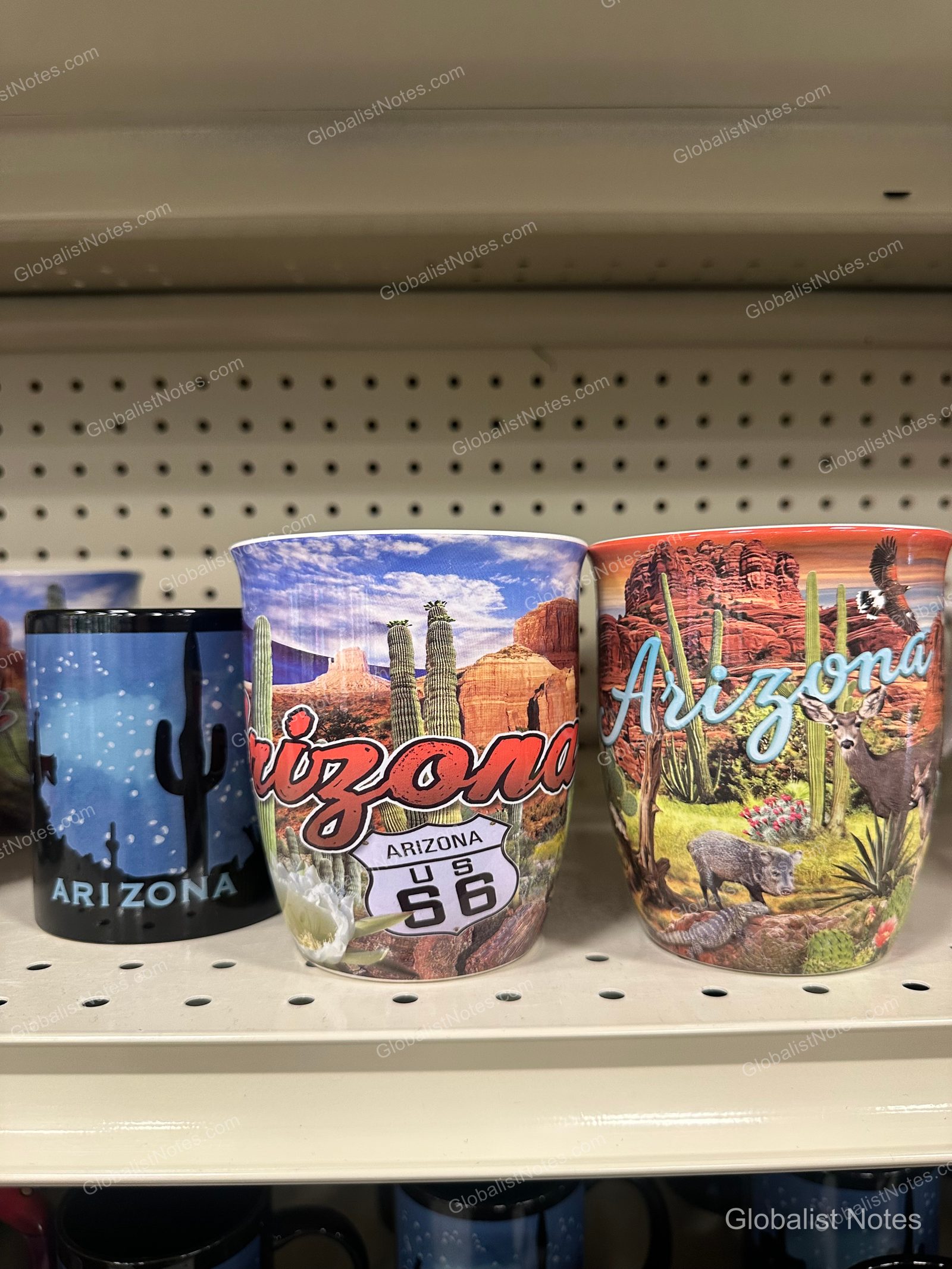 Hyatt Place Tucson Central 販售區展示的三個亞利桑那州紀念馬克杯。杯身繪有沙漠風景、仙人掌、地名及 66 號公路標誌等鮮豔圖案。