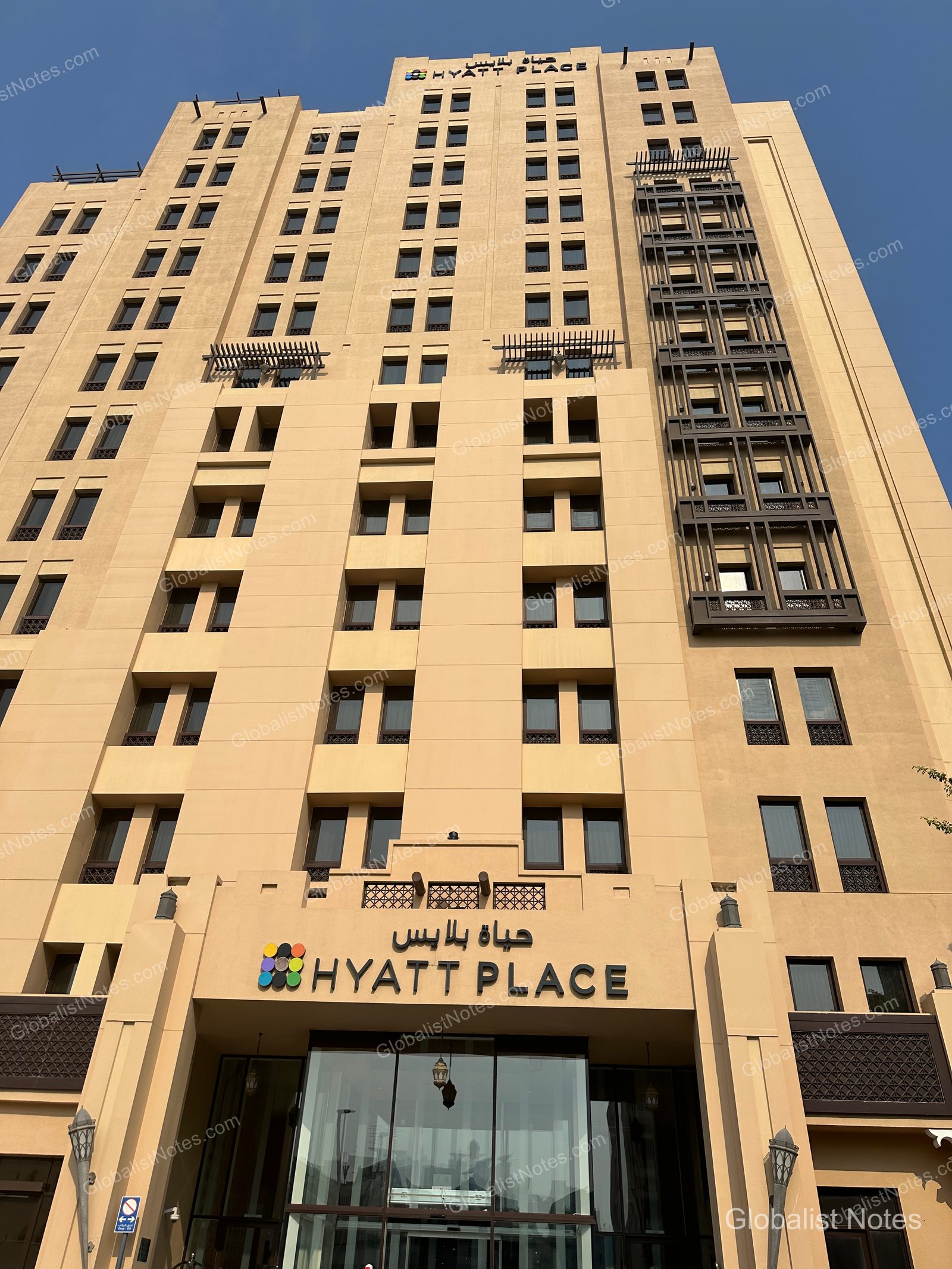 位於杜拜 Wasl District 的 Hyatt Place 外觀。這棟米色調高層建築的入口處設有 Hyatt Place 標誌與阿拉伯語招牌，建築右側則有獨特的格紋陽台結構。
