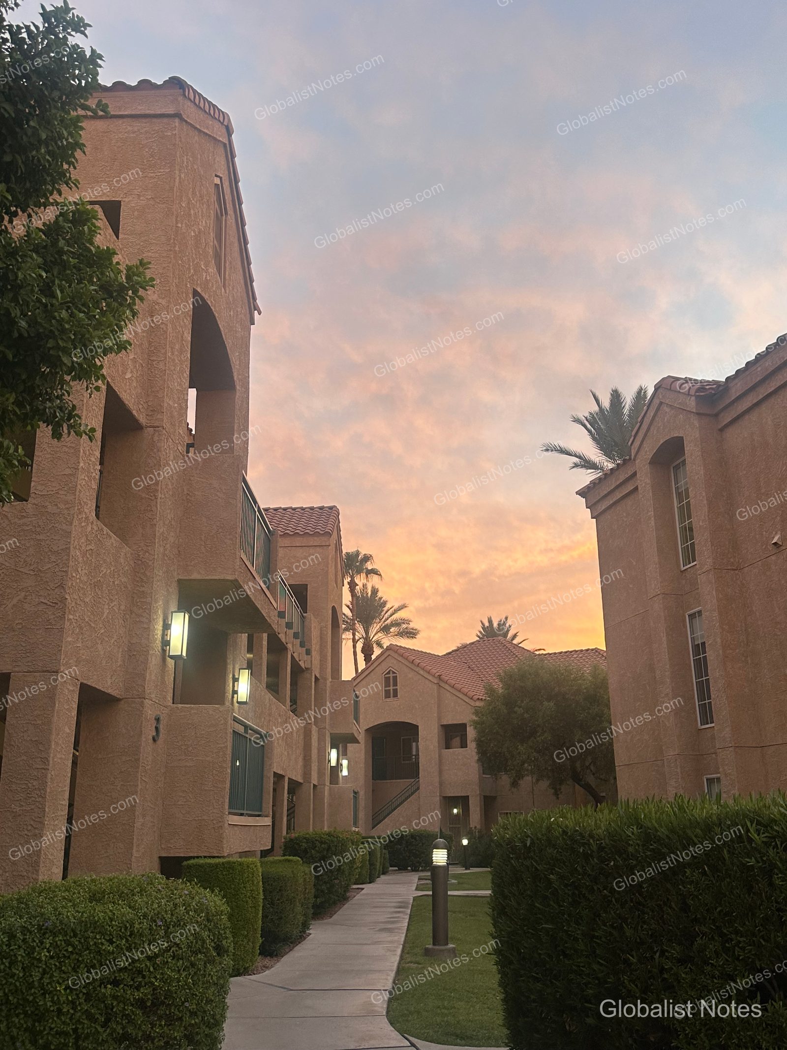 夕暮れ時のHyatt House Scottsdale/Old Town。黄土色の低層の建物が並び、その間を散策路が続いています。