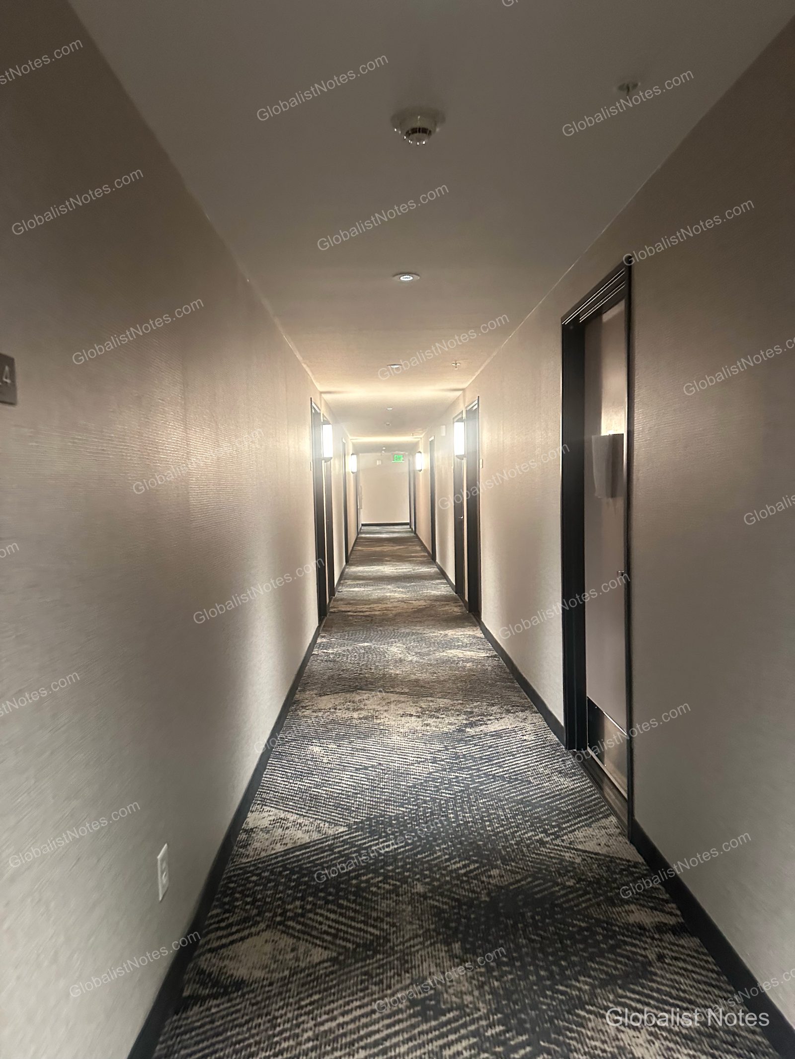 Hyatt Place Flagstaffの客室廊下。幾何学模様のカーペットが敷かれ、天井の照明が奥まで続いています。
