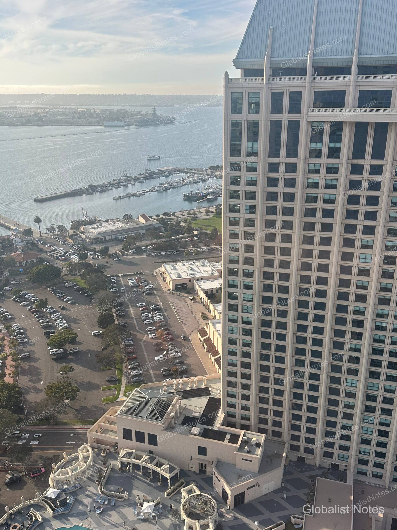 從 Manchester Grand Hyatt San Diego 高樓層客房俯瞰，右側可見飯店另一棟塔樓，下方則是停車場、聖地牙哥港口的遊艇與廣闊海景。