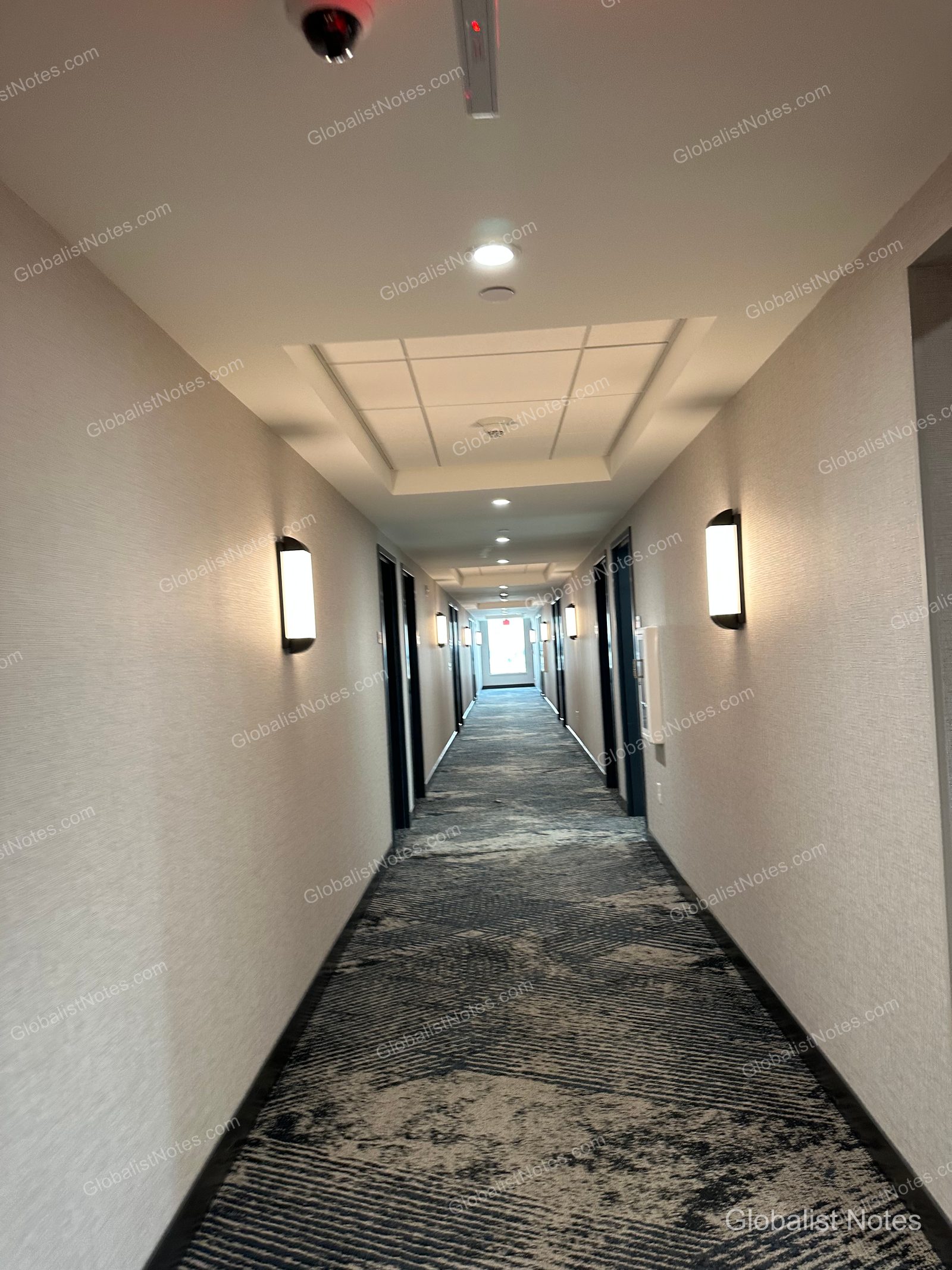 Hyatt Place Bozeman Yellowstone Airportの客室廊下。両側にドアが並び、床にはダークグレーと白のパターンカーペットが敷かれています。