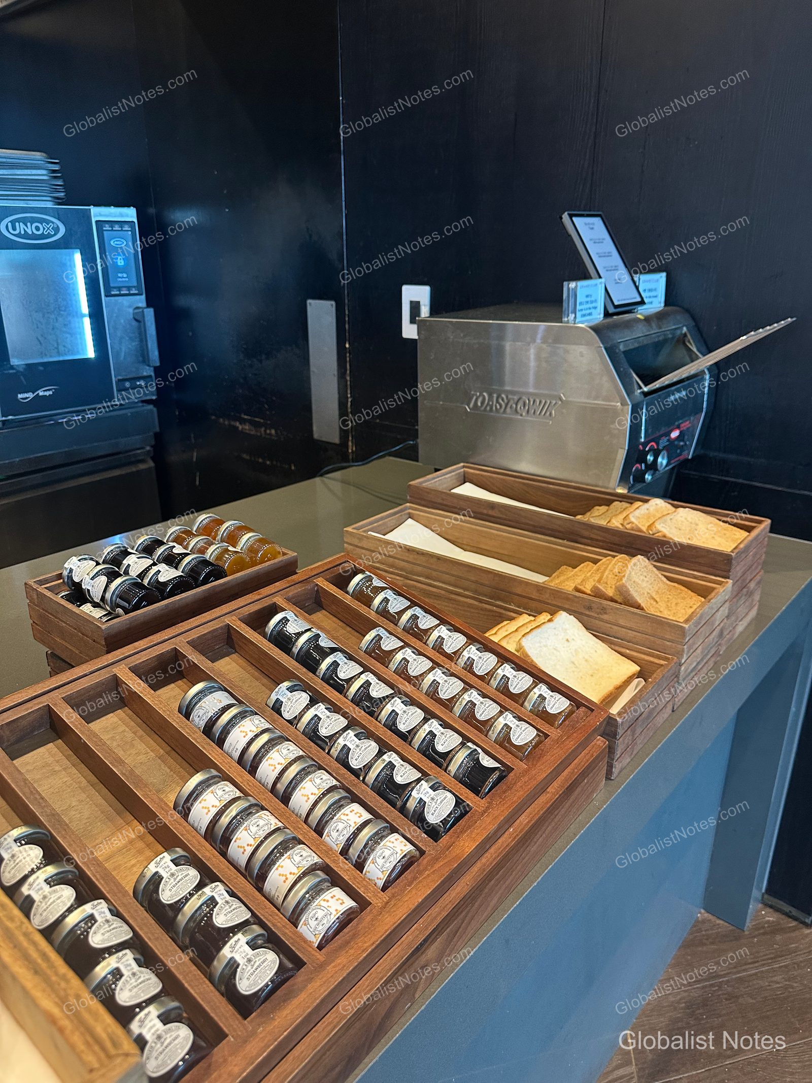 Bakery station at the Grand Hyatt Jeju breakfast buffet, featuring individual portions of jam and butter on wooden trays, with sliced bread and toasters nearby.