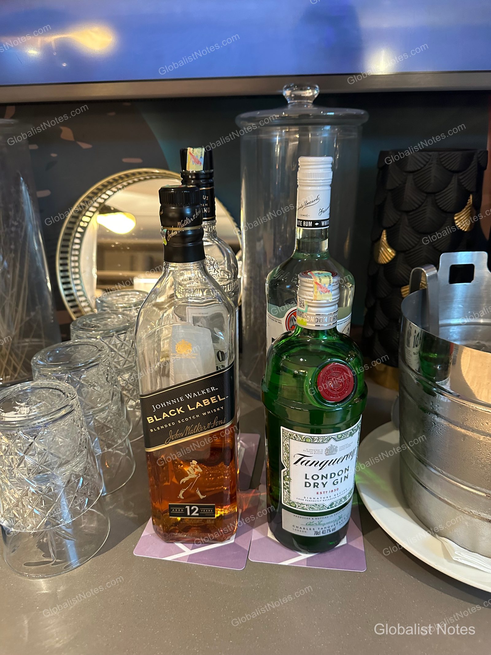 A selection of spirits, including Johnnie Walker Black Label, Tanqueray, and Bacardi, arranged with glassware in the Hyatt Regency Malta lounge.