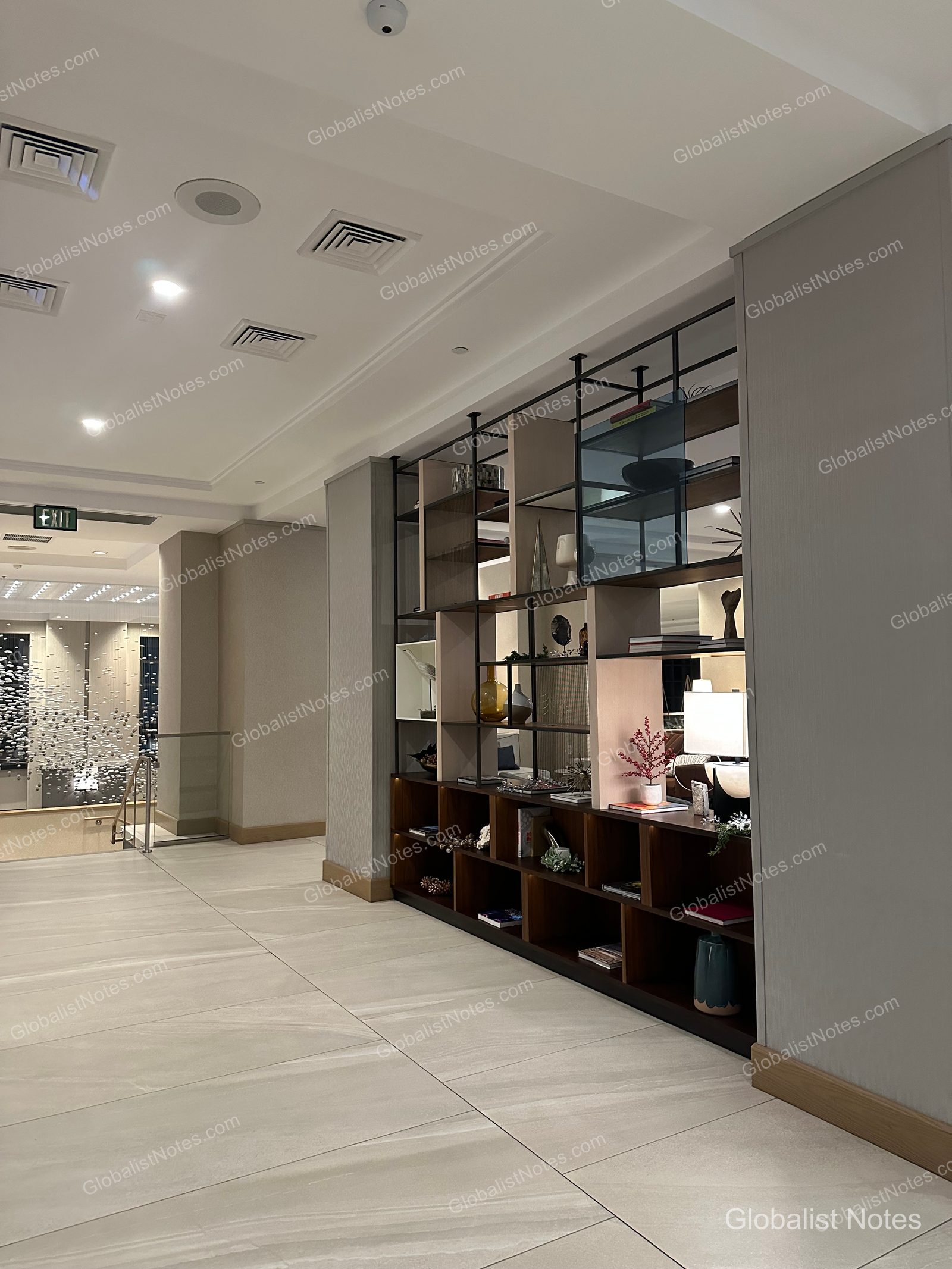 Hyatt Regency La Jolla at Aventine 大廳，明亮的磁磚地板與映照著燈光的走廊旁，設有擺放裝飾品的大型開放式層架。