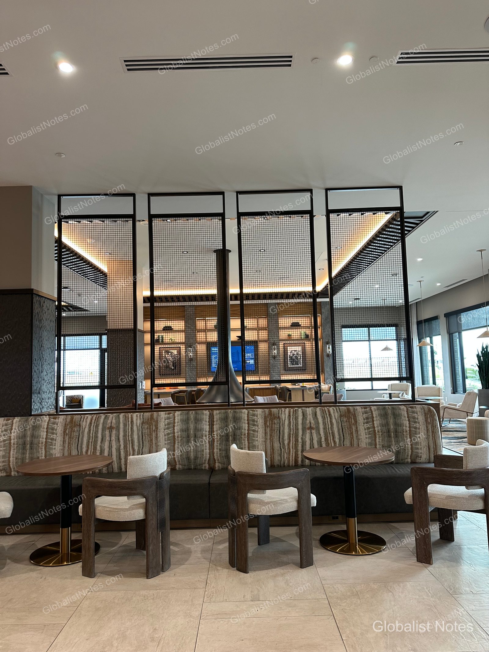Hyatt Place Bozeman Yellowstone Airportのロビーラウンジ。ソファ席やテーブルが配置され、奥には暖炉が備わったモダンで落ち着いた空間です。