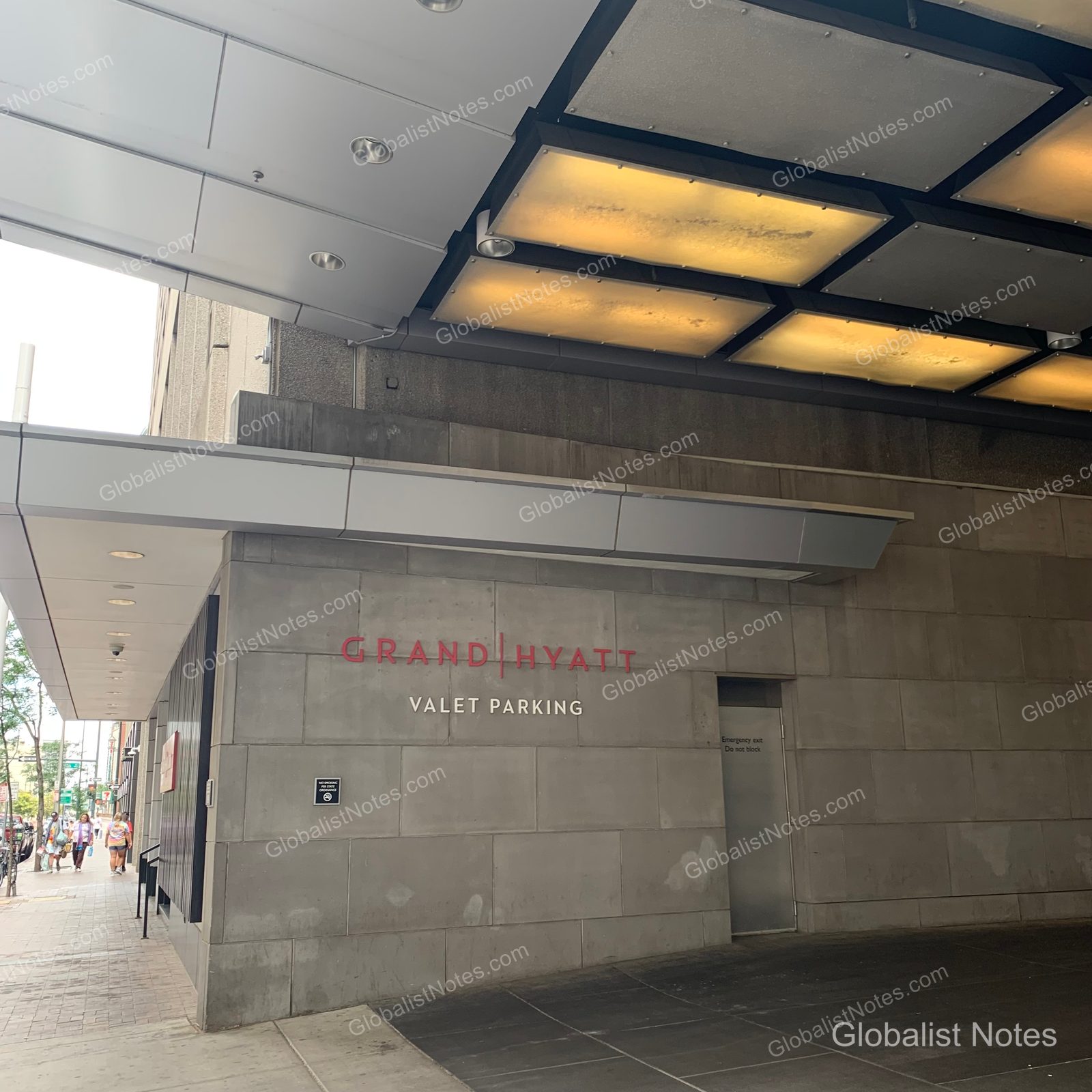 Grand Hyatt Denverのバレーパーキング入り口。グレーの石壁に赤いGrand Hyattのロゴと案内が掲示され、モダンな照明が備わった車寄せが見える。