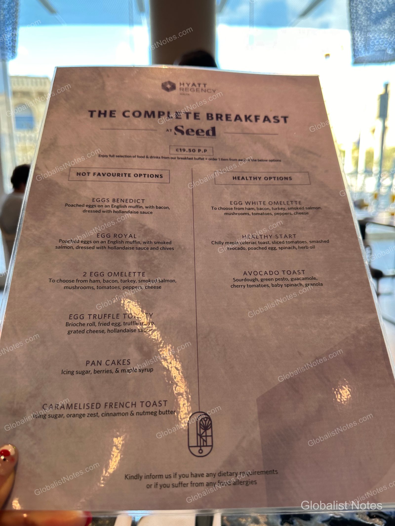 The breakfast menu at Seed restaurant in the Hyatt Regency Malta, listing 'Hot Favorites' and 'Healthy Options' like Eggs Benedict, omelets, and avocado toast for 19.50 EUR.