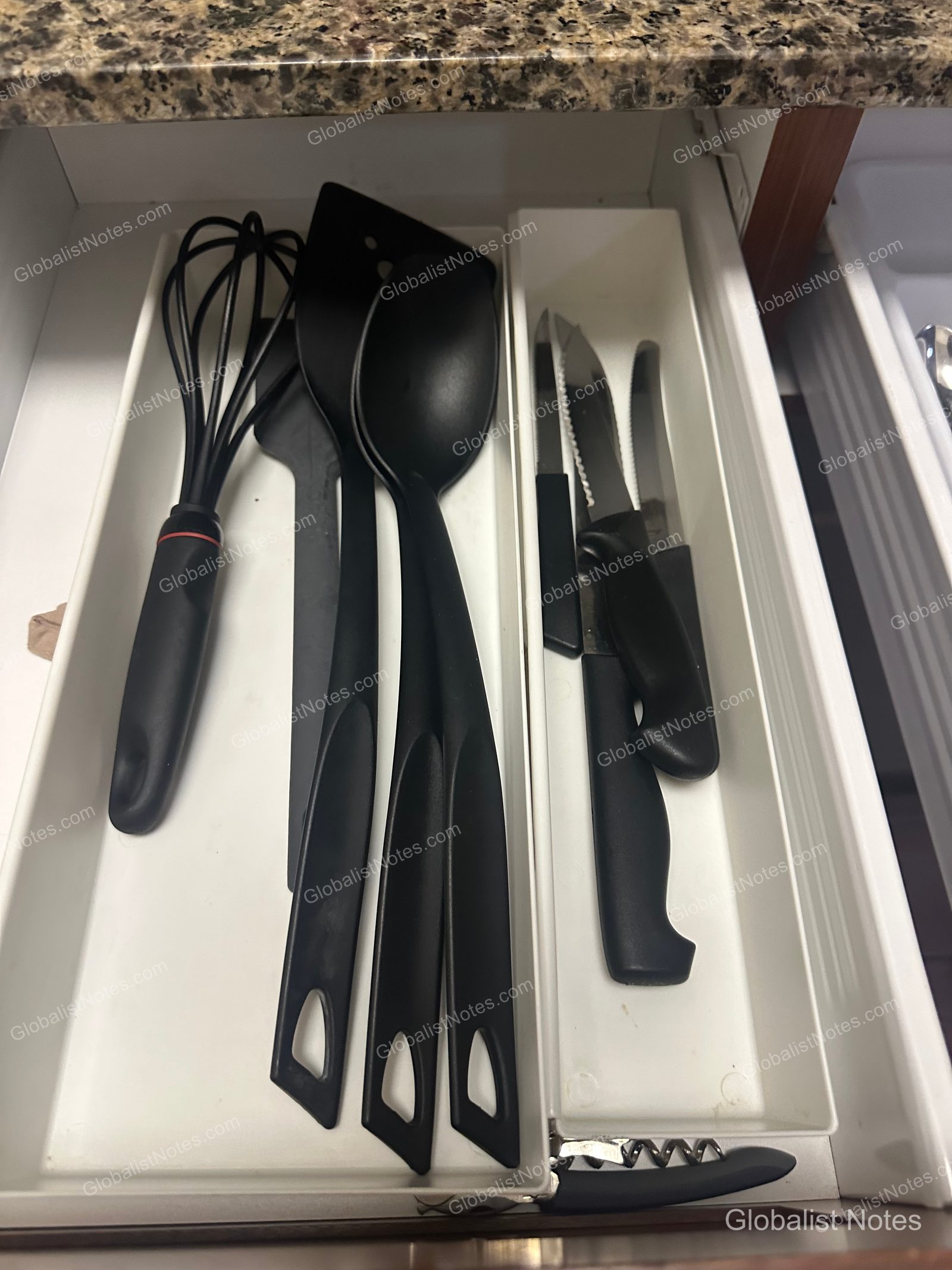 Hyatt House Scottsdale/Old Townのワンベッドルームスイートのキッチン引き出し。泡立て器、フライ返し、調理用スプーン、包丁、ワインオープナーなどの調理器具がトレイに整理されている。