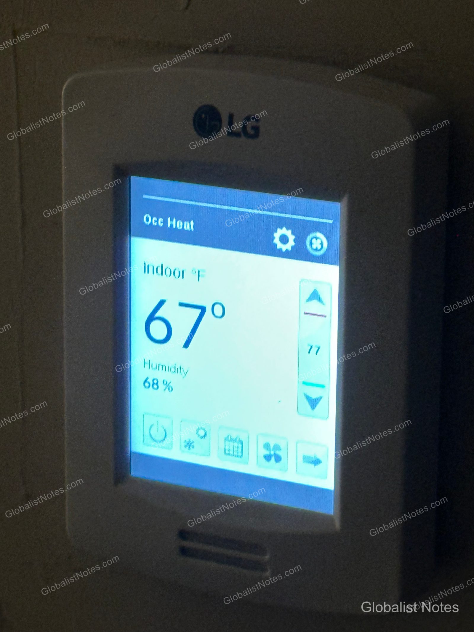 LG digital thermostat on the hotel room wall showing 67°F; the heating mode is selected but not actively running.