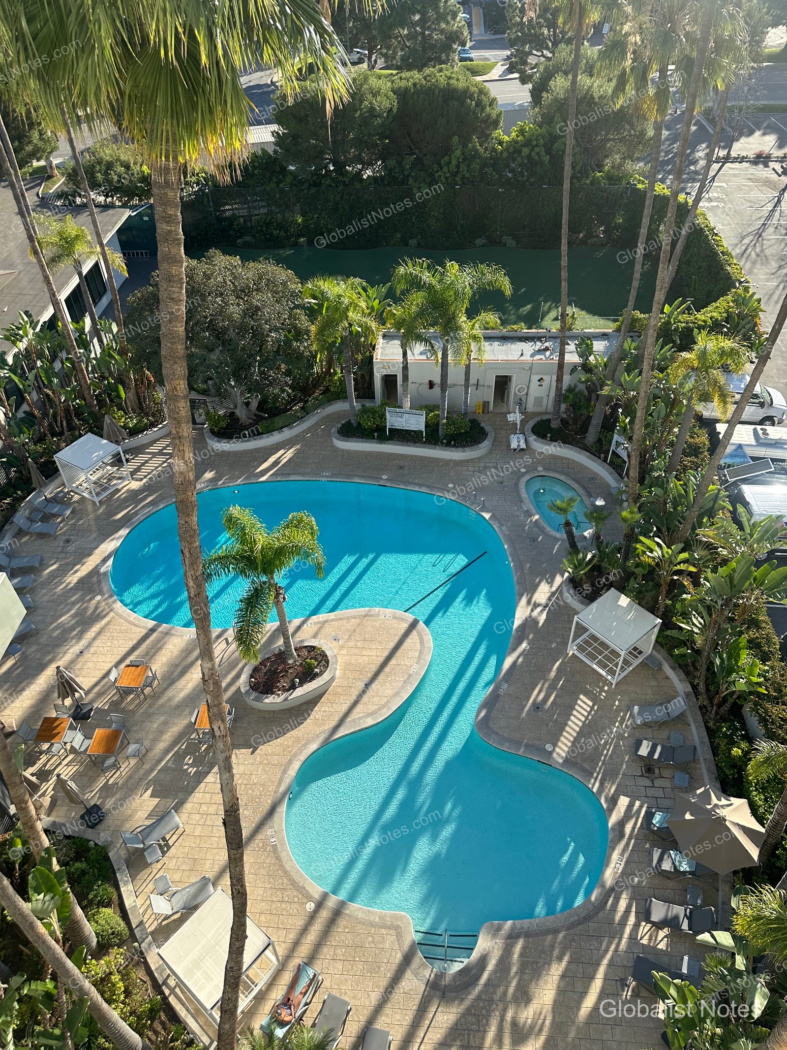 從高處俯瞰 Hyatt Regency Newport Beach West 的戶外泳池，可見曲線型泳池、小型熱水按摩池，以及周邊配置的躺椅、遮陽傘與休憩區。
