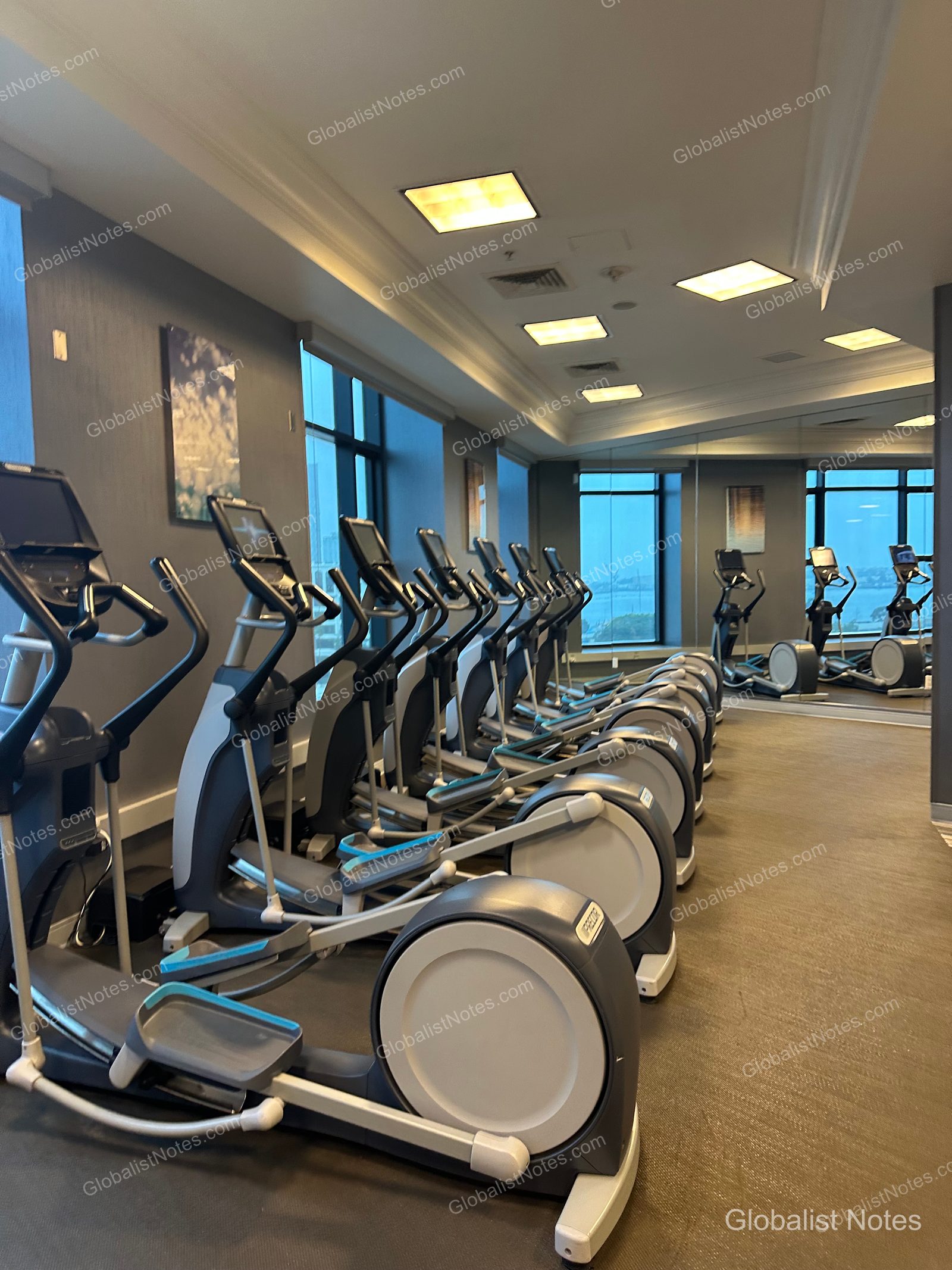 Manchester Grand Hyatt San Diego 健身中心內部。多台 Precor 橢圓機沿窗排列，牆面大鏡面映照出寬敞空間。