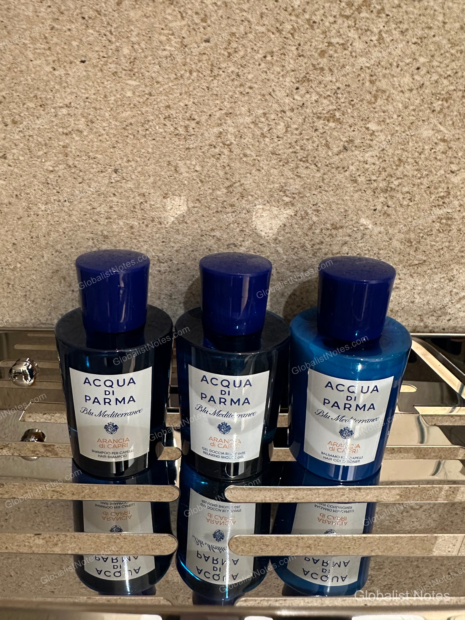 Acqua di Parma Blu Mediterraneo shampoo, shower gel, and conditioner on a metal shelf in the Junior Suite bathroom at Hyatt Regency Malta.