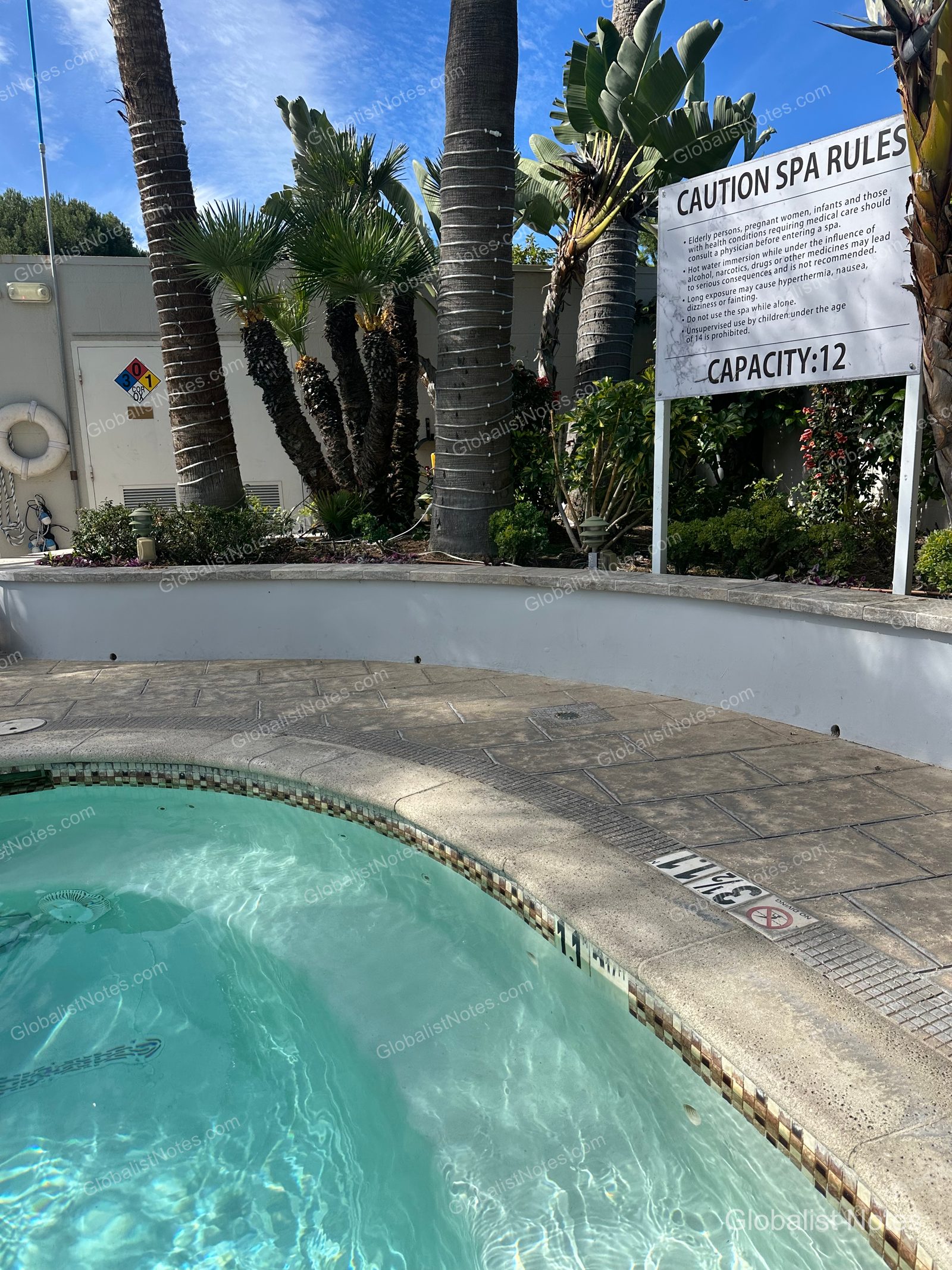 Hyatt Regency Newport Beach West 的戶外 SPA 區，設有圓形熱水按摩池與使用規範告示牌，周圍環繞棕櫚樹與景觀植栽。